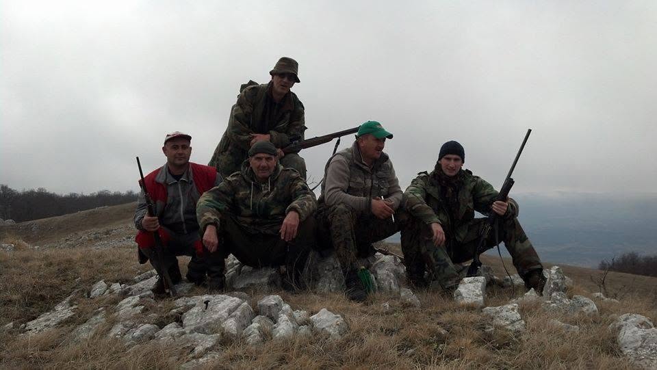 Grupa lovaca odmara na kamenitom planinskom grebenu